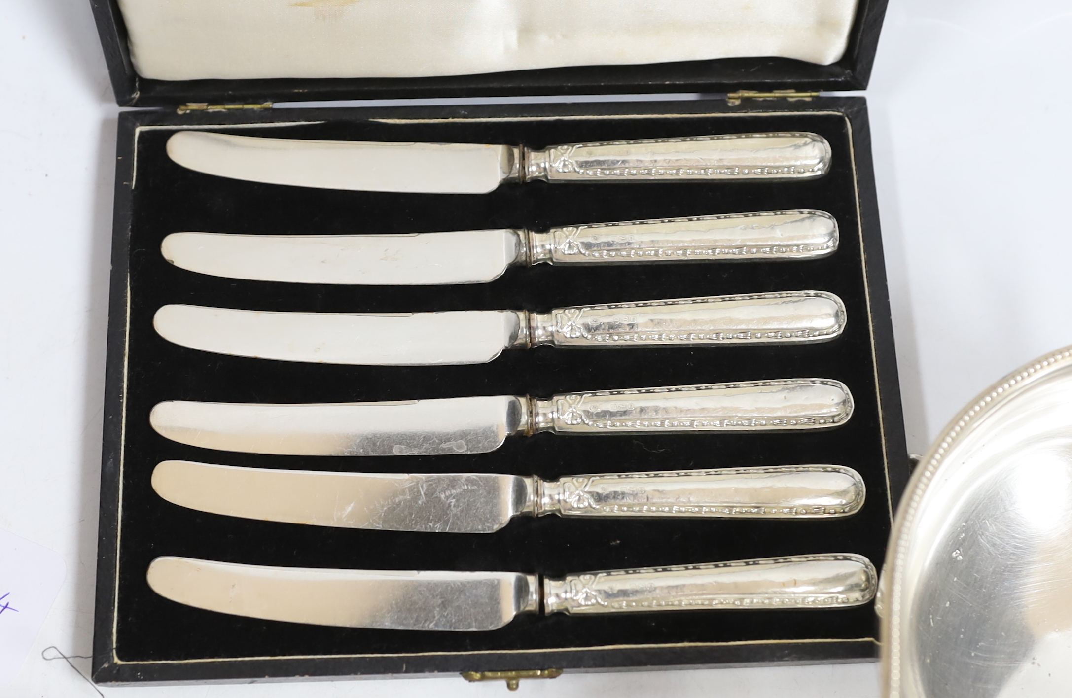 A small collection of silver including a sauceboat, two handled shallow bowl, five teaspoons and a commemorative spoon, together with a sterling cream jug and sugar bowl, sterling flatware and set of four pepperettes, to